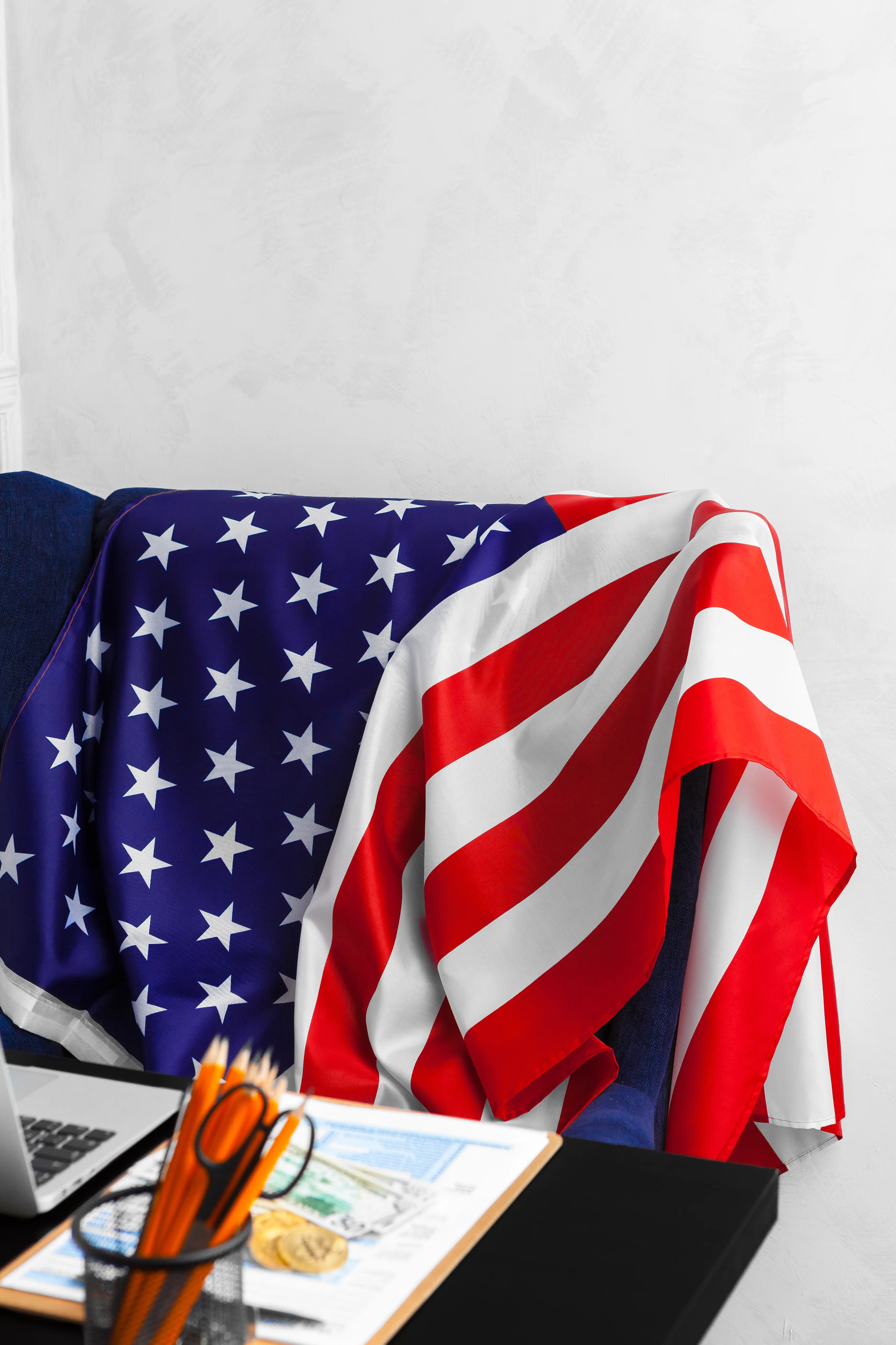 Golden Bitcoin coins on dollar banknotes against an office background.